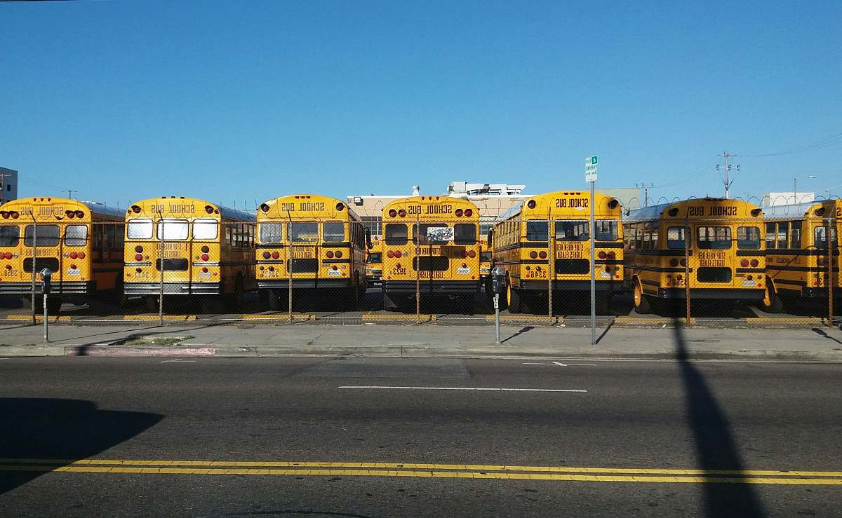 bus photo of yellow bus park on parking lot transportation